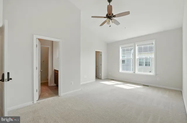 a view of a big room with windows and chandelier fan