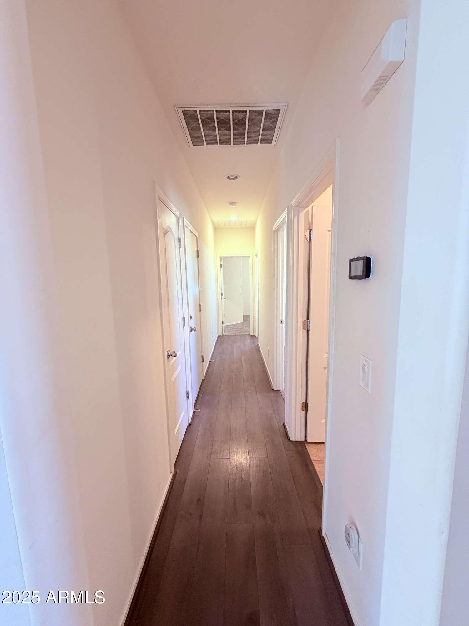 21121 East Via De Olivos Queen Creek, AZ 85142 - Photo 19 of 34 a view of a hallway with a wooden floor