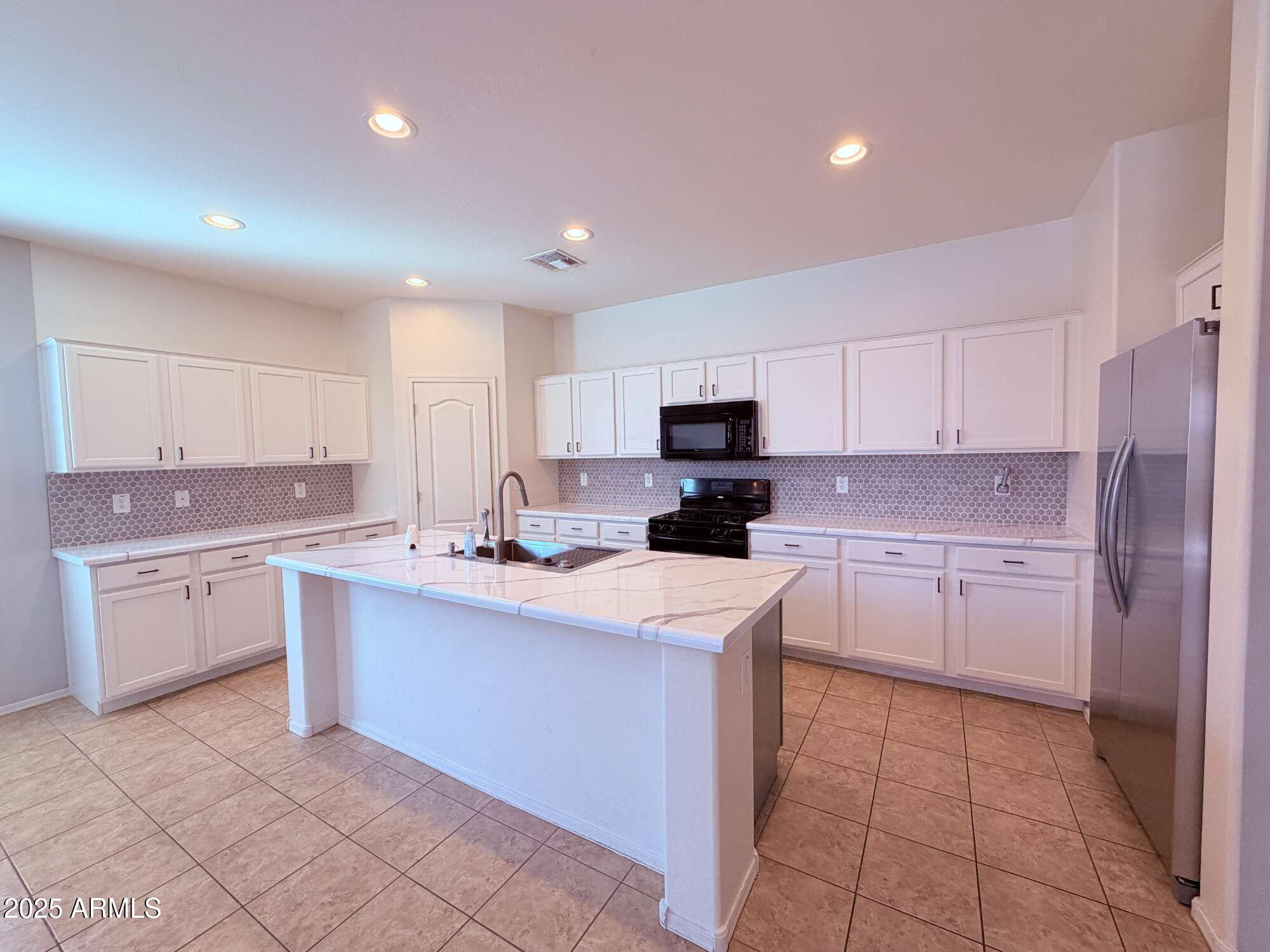 21121 East Via De Olivos Queen Creek, AZ 85142 - Photo 28 of 34 a kitchen with a sink a stove top oven and white cabinets