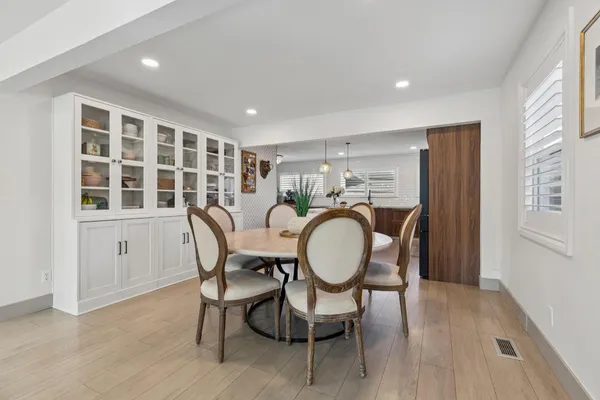 a dining room with furniture a window and wooden floor