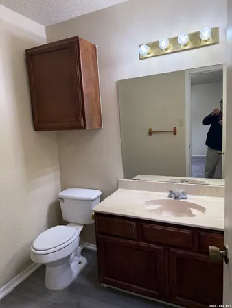 a bathroom with a sink a toilet and mirror