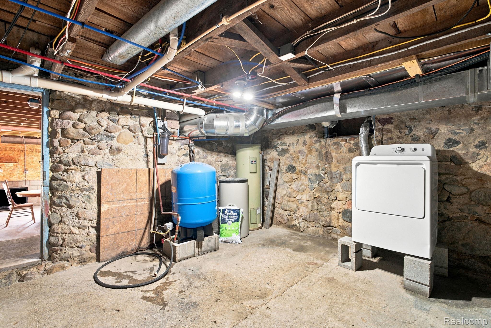 4201 Galbraith Line Road Croswell, MI 48422 - Photo 28 of 39 Utility room featuring exposed stone foundation walls and concrete flooring