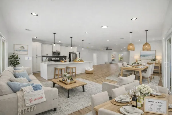 a living room with furniture kitchen and a chandelier