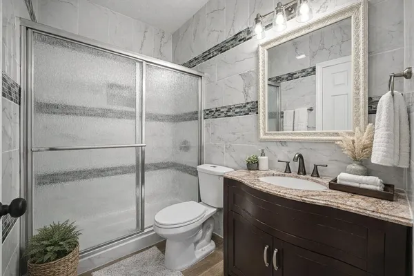 a bathroom with a sink a toilet and shower