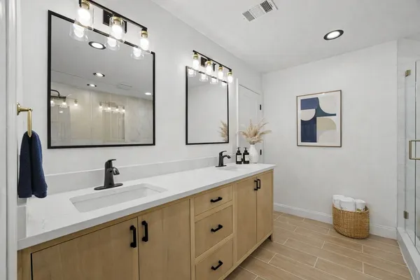 a bathroom with a double vanity sink and a mirror