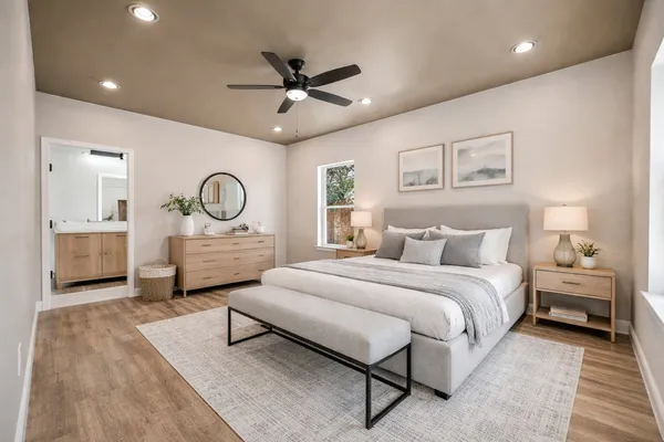 a bedroom with a large bed and a potted plant