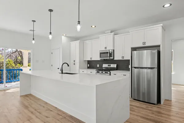 a kitchen with stainless steel appliances granite countertop a stove a sink and a microwave
