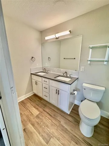 a bathroom with a granite countertop toilet sink and mirror