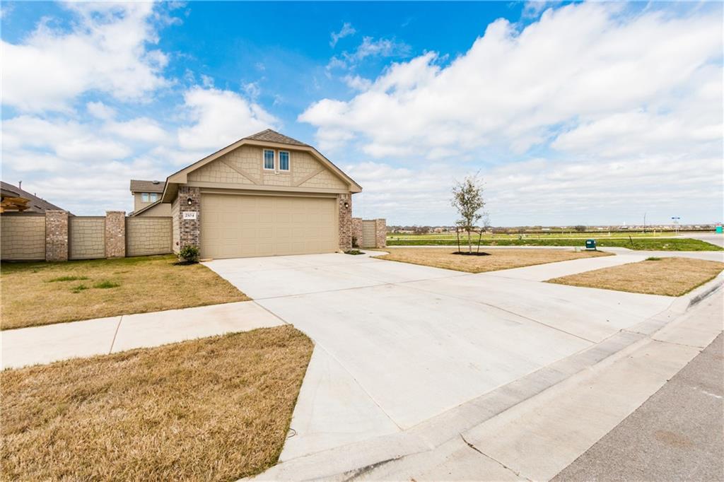 2104 Pindos Pony Way Georgetown, TX 78626 - Photo 2 of 30 A well-maintained concrete driveway leads to this charming home with a neatly landscaped front yard.