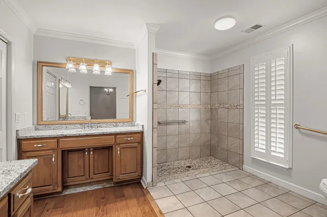 a bathroom with a granite countertop sink a large mirror and a shower