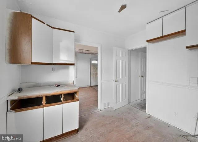 a kitchen with stainless steel appliances granite countertop a sink a stove and white cabinets with wooden floor