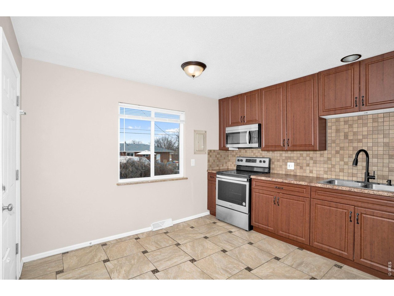 2616 23rd Avenue Greeley, CO 80634 - Photo 13 of 21 a kitchen with stainless steel appliances granite countertop a sink stove and refrigerator