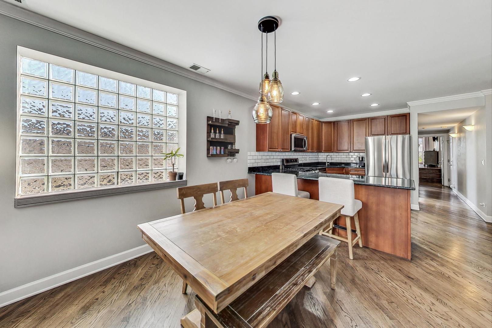 951 West Fletcher Street, Unit 2 Chicago, IL 60657 - Photo 7 of 26 a open kitchen with stainless steel appliances granite countertop a stove a refrigerator a kitchen island a sink dishwasher and a wooden cabinets