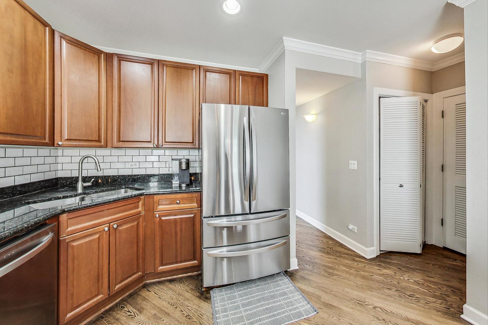 951 West Fletcher Street, Unit 2 Chicago, IL 60657 - Photo 9 of 26 a kitchen with granite countertop wooden cabinets and stainless steel appliances