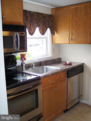 8575 Beacon Point Road Pasadena, MD 21122 - Photo 1 of 13 a kitchen with stainless steel appliances granite countertop a sink stove and cabinets