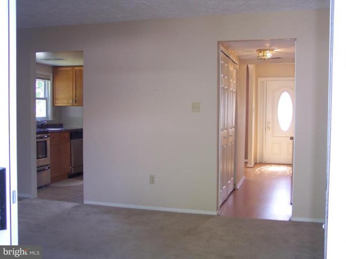 8575 Beacon Point Road Pasadena, MD 21122 - Photo 12 of 13 a view of a hallway with wooden floor and a living room