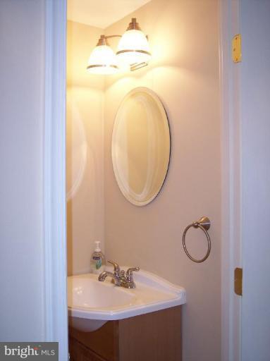 8575 Beacon Point Road Pasadena, MD 21122 - Photo 8 of 13 a bathroom with a sink and a mirror