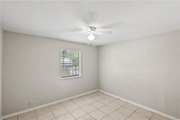 an empty room with windows and fan