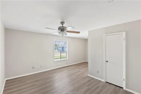 a view of a room with wooden floor and ceiling fan