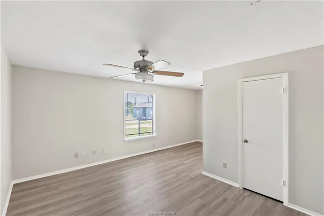 a view of a room with wooden floor and ceiling fan