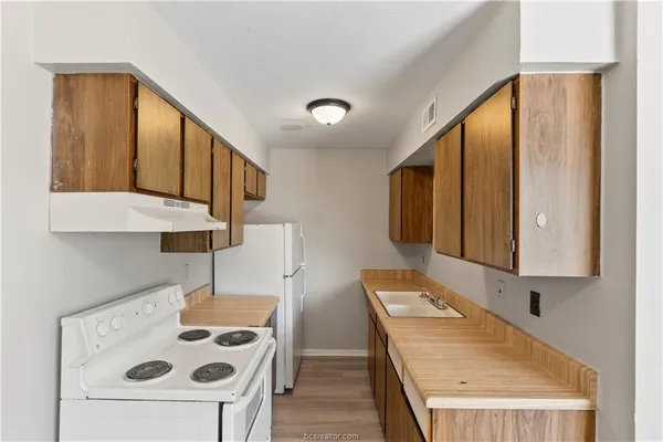 a kitchen with a refrigerator and a stove