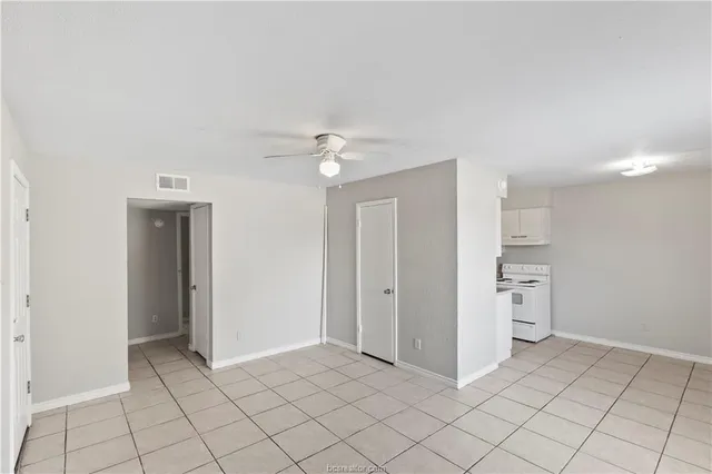 an empty room with closet and windows