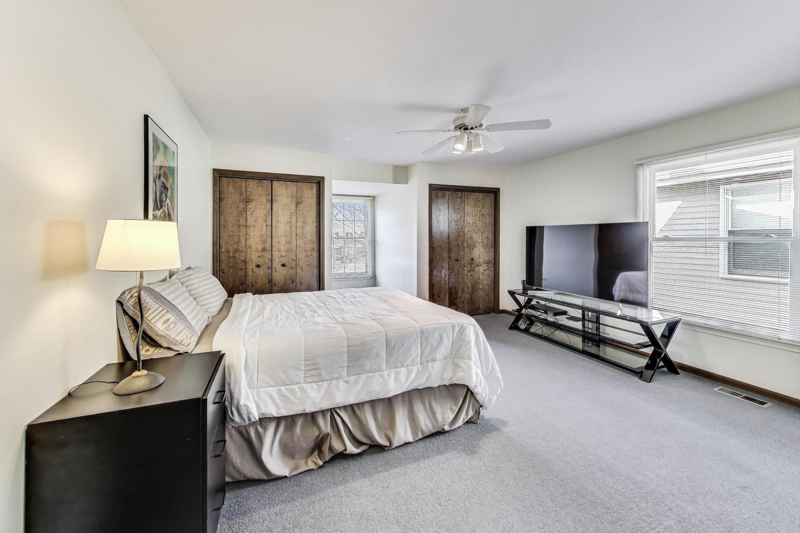 2207 North Brighton Place Arlington Heights, IL 60004 - Photo 22 of 37 a spacious bedroom with a bed and a flat screen tv