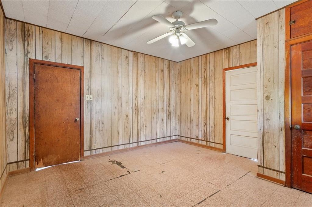 100 County Road 120 C Riesel, TX 76682 - Photo 5 of 25 Spare room with tile patterned floors, wooden walls, and a ceiling fan