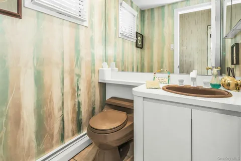 a bathroom with a sink a toilet and a mirror