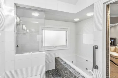 a bathroom with a tub shower and sink