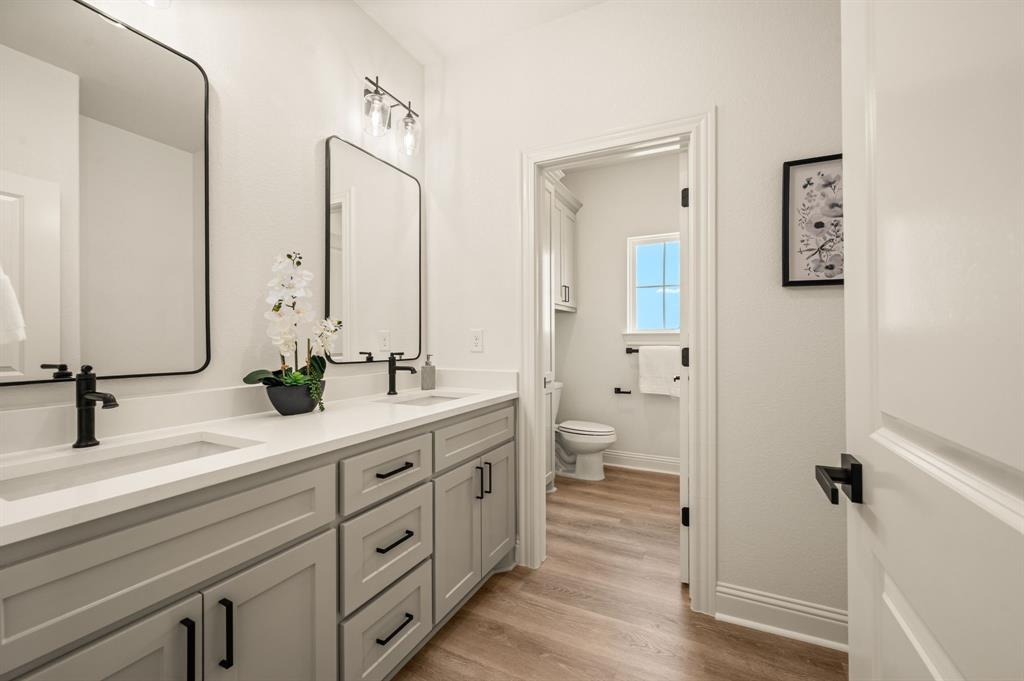 2705 Gospel Road Tolar, TX 76476 - Photo 24 of 36 Dual sink vanity with light gray cabinetry, quartz countertop, and matte black hardware