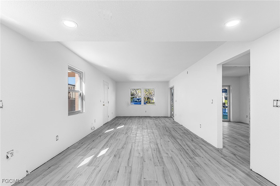 16881 Davis Road, Unit 412 Fort Myers, FL 33908 - Photo 11 of 27 an empty room with wooden floor and windows