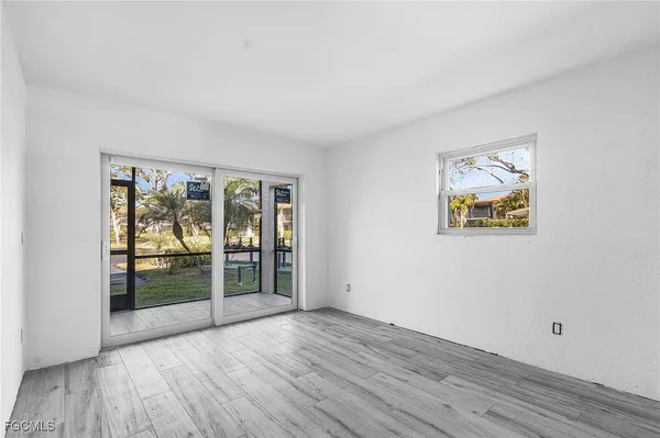an empty room with wooden floor and glass door