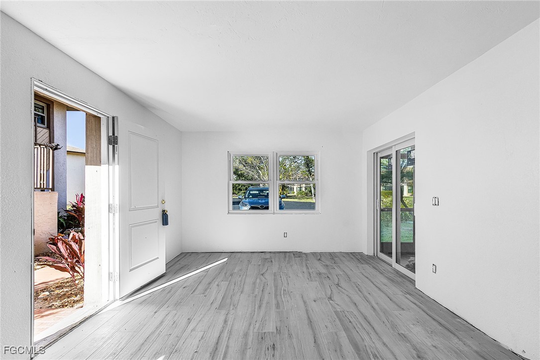 16881 Davis Road, Unit 412 Fort Myers, FL 33908 - Photo 6 of 27 an empty room with wooden floor and windows