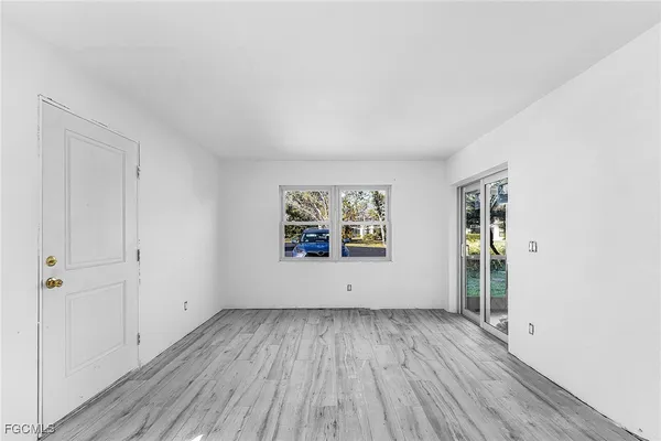 an empty room with wooden floor and window