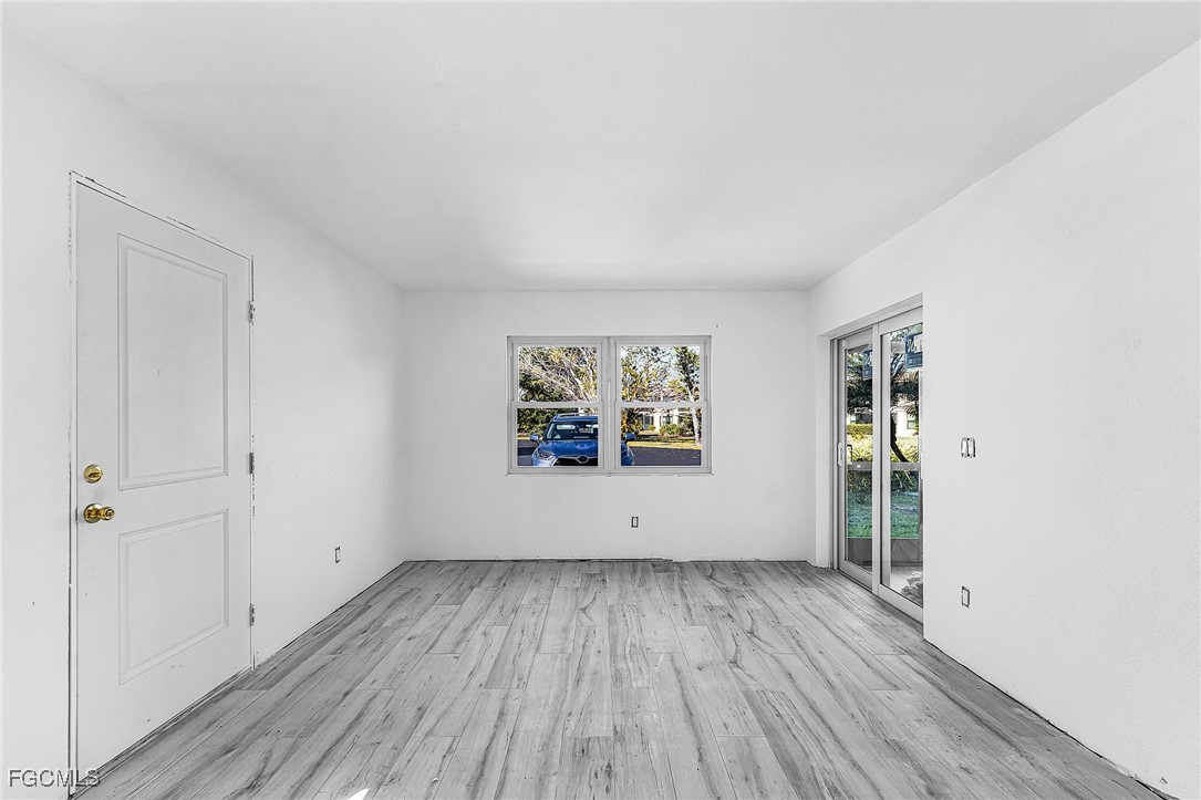 16881 Davis Road, Unit 412 Fort Myers, FL 33908 - Photo 7 of 27 an empty room with wooden floor and window