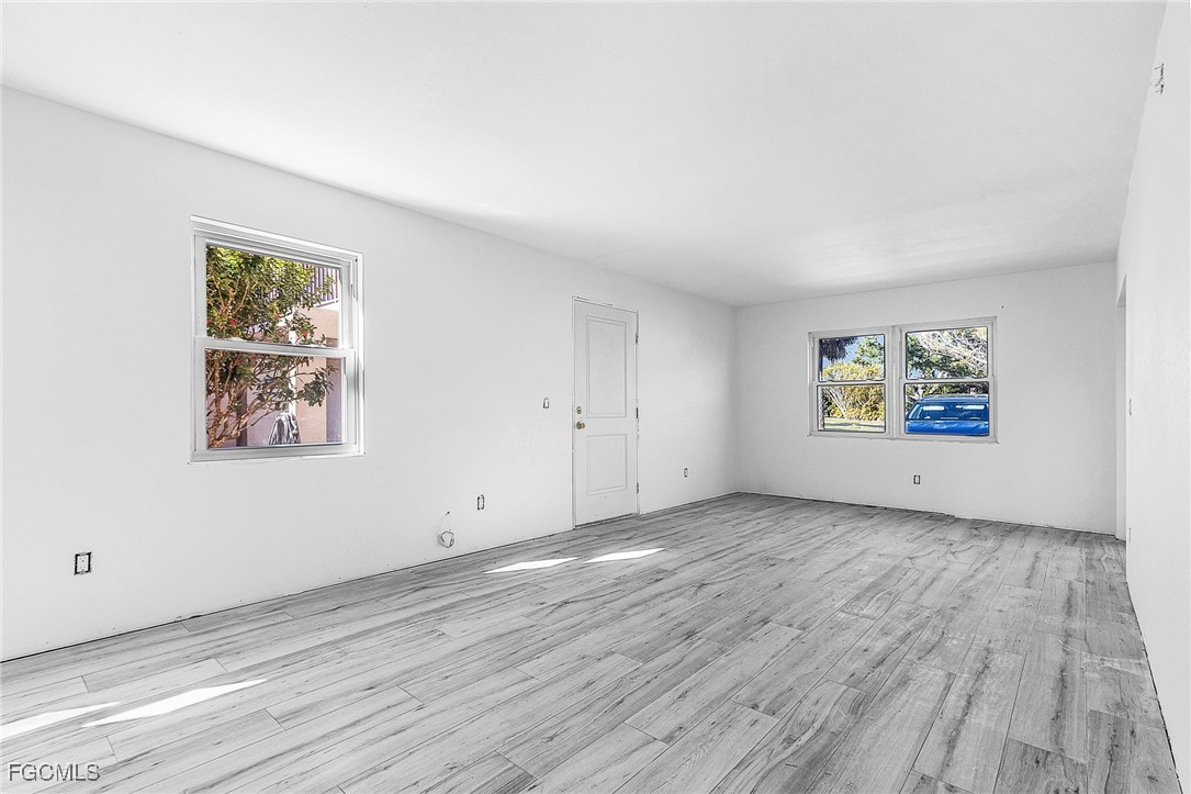 16881 Davis Road, Unit 412 Fort Myers, FL 33908 - Photo 8 of 27 an empty room with wooden floor and window
