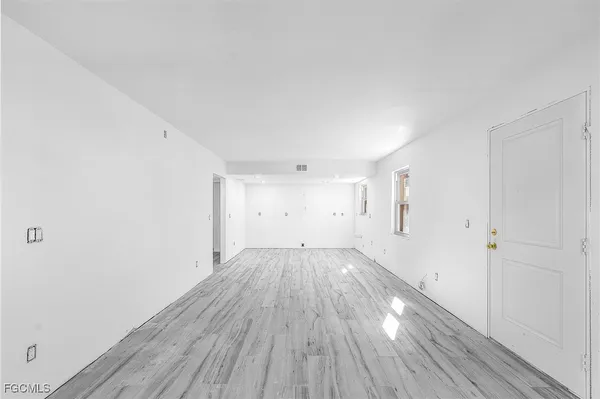 a view of an empty room with wooden floor