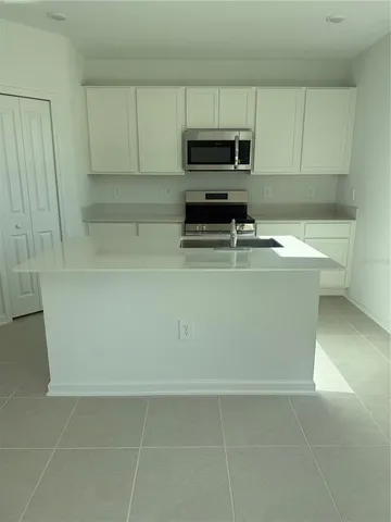 a view of a kitchen with microwave and sink