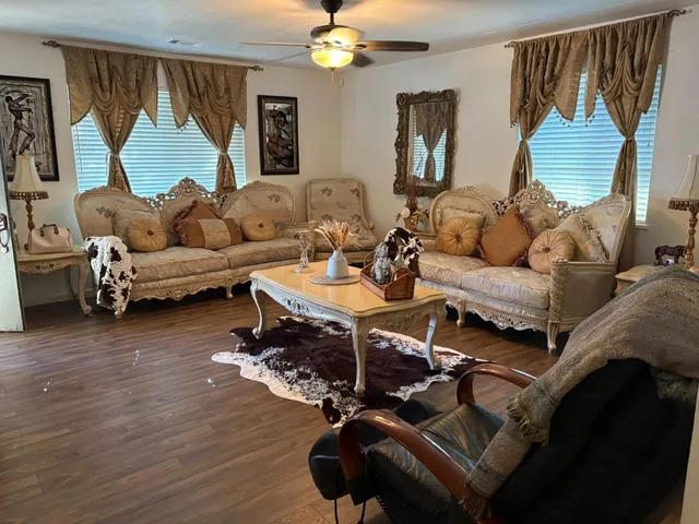 a living room with furniture a chandelier and a window