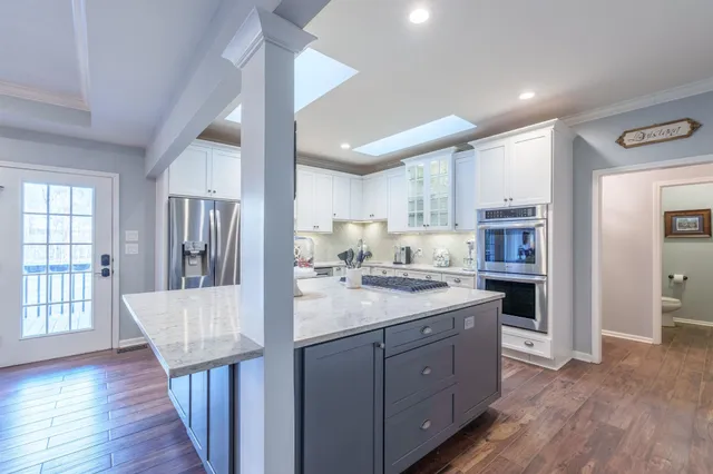 a kitchen with granite countertop kitchen island a sink stove and refrigerator