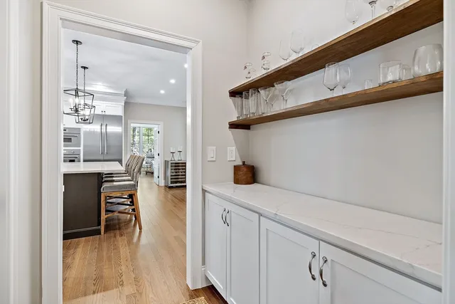 a hallway with white cabinets and wooden floor