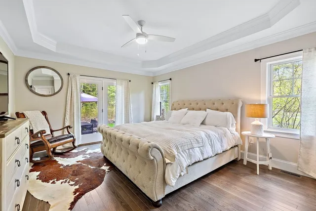 a bedroom with a bed a mirror and a large window