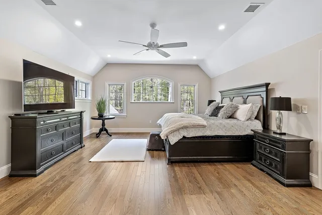 a spacious bedroom with a bed and a flat screen television