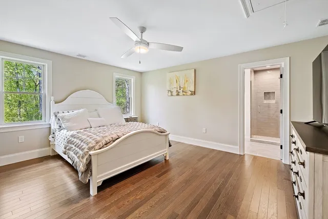 a bedroom with a bed wooden floor and window