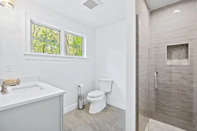 a bathroom with a sink a toilet and a window