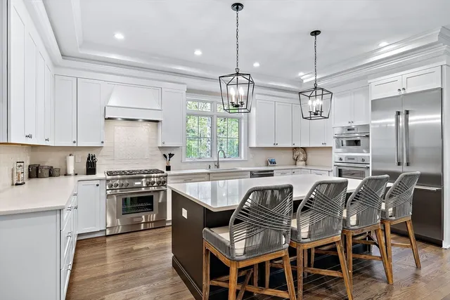 a kitchen with stainless steel appliances a stove a sink a center island and a center island