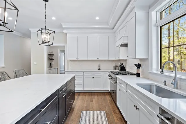 a kitchen with a sink dishwasher a stove top oven a refrigerator with island and cabinets