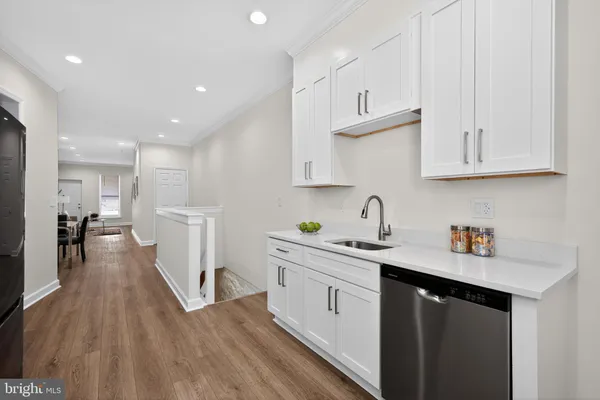 a kitchen with white cabinets sink and stainless steel appliances
