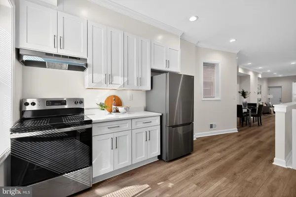 a kitchen with stainless steel appliances granite countertop a refrigerator and a stove top oven